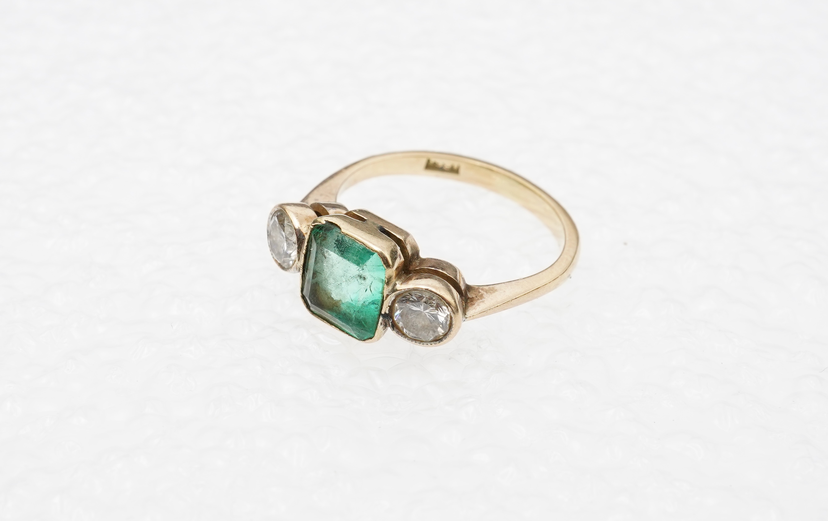 An emerald and diamond ring